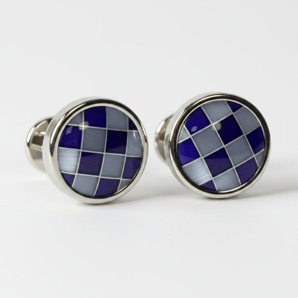 Pair of cufflinks with blue and silver checkered design on a white background