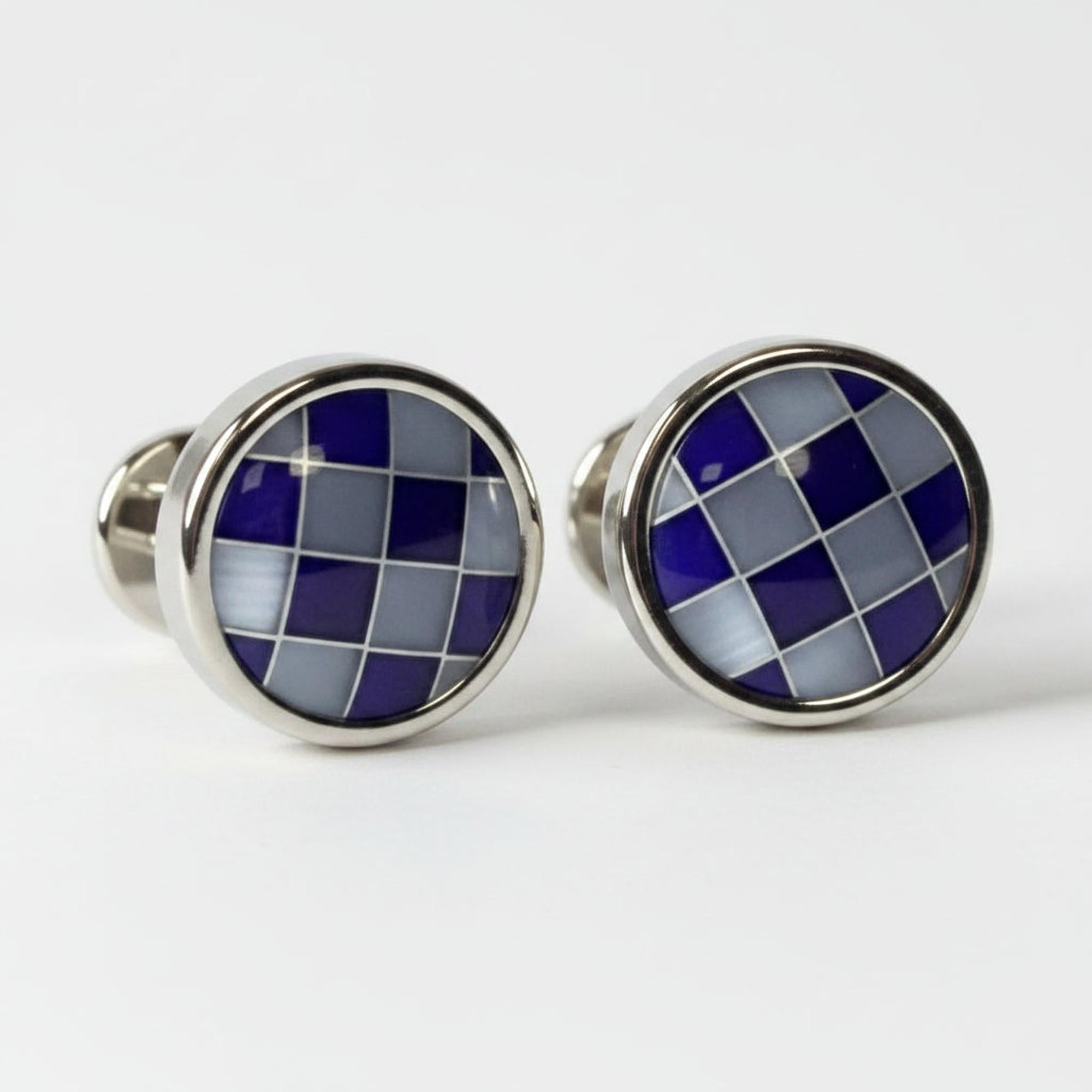Pair of cufflinks with blue and silver checkered design on a white background
