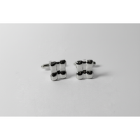Pair of silver cufflinks on a light gray background