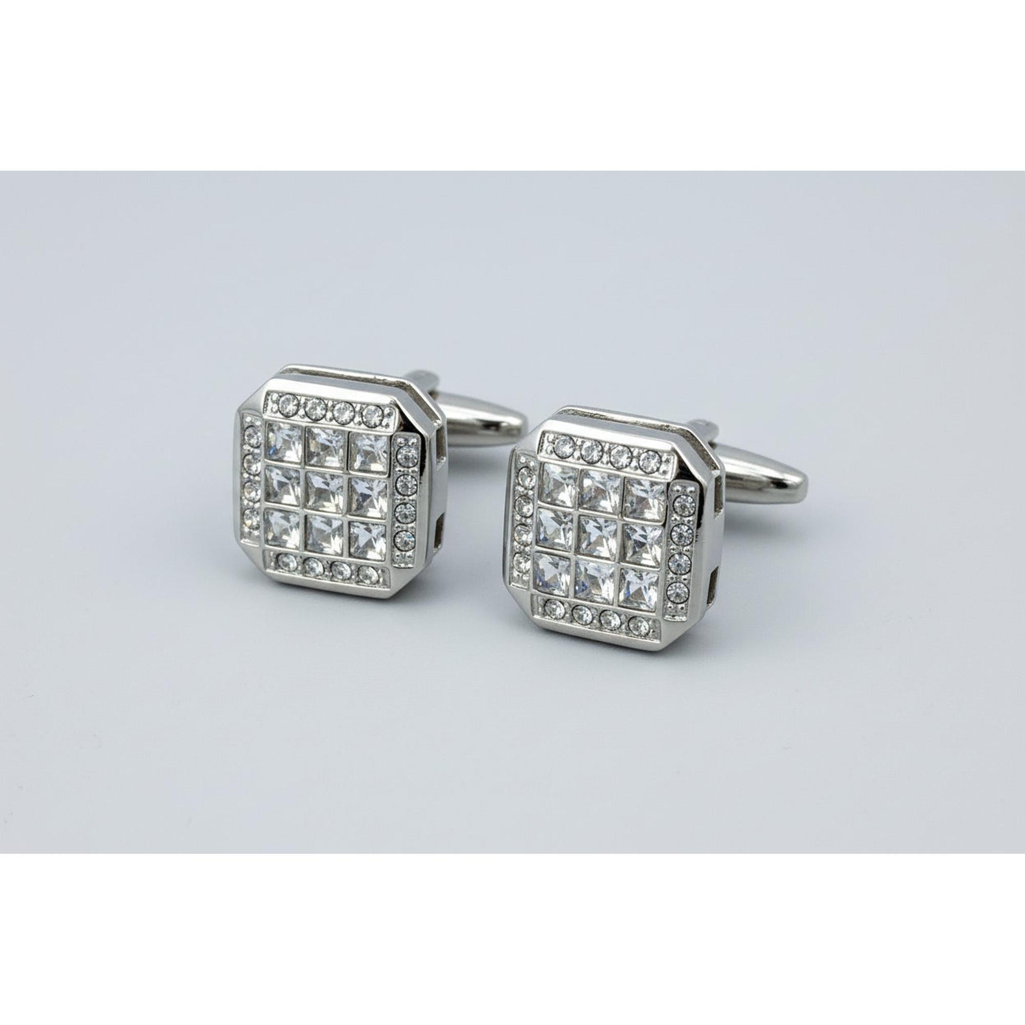 Silver cufflinks with crystal stones on a white background