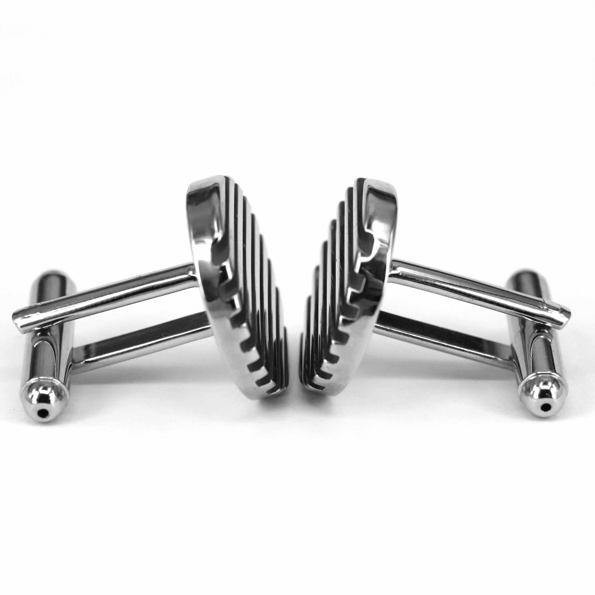 Metallic cufflinks with a unique design on a white background