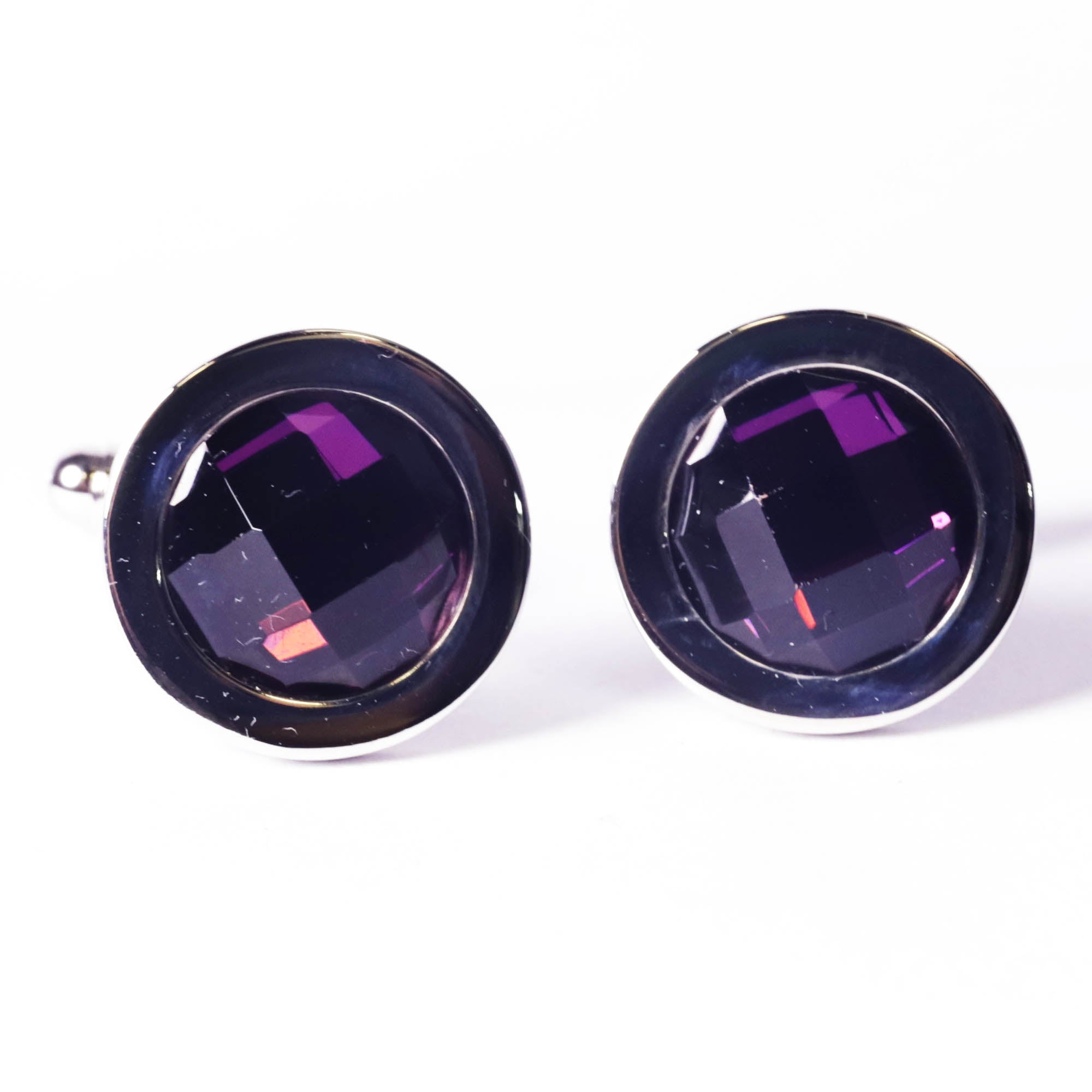 Pair of round cufflinks with purple gemstones on a white background